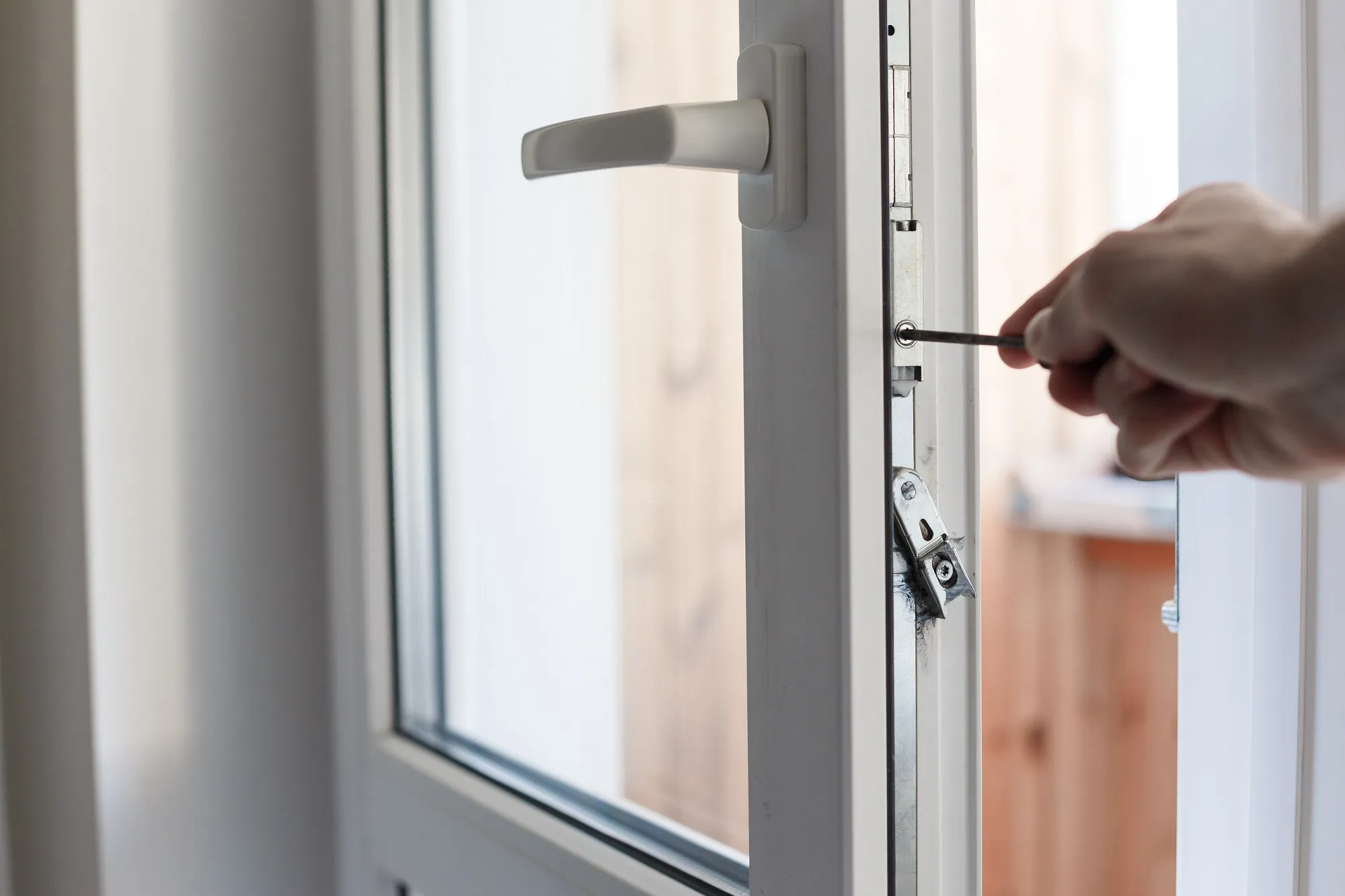 A person is opening a glass door with a key.